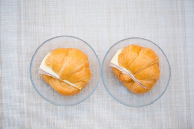 Jambonlu ve peynirli sandviç kruvasan cam tabak