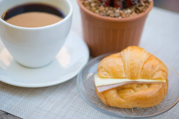 Croissant de jamón y queso con fondo de café — Foto de Stock