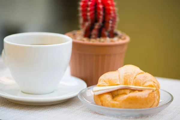 Uma xícara de café preto com presunto e croissant de queijo — Fotografia de Stock