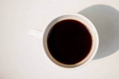 Masada beyaz bir fincan ve sade kahve.