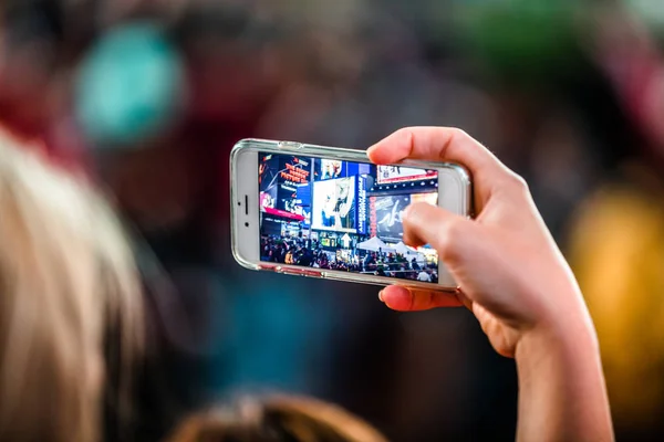 Alguém tirando uma foto com um iPhone de Times Square — Fotografia de Stock