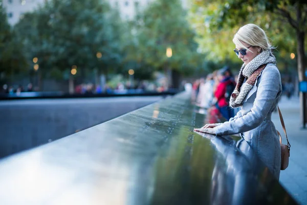 Женщина, смотрящая на имена Мемориала Всемирного торгового центра — стоковое фото