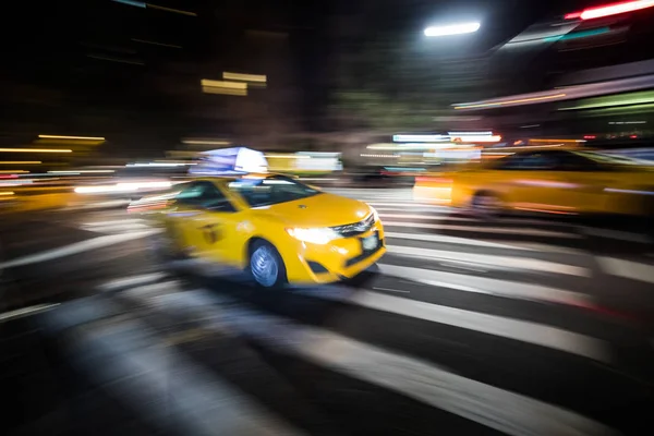 NYC Yellow Cab passando rápido à noite — Fotografia de Stock