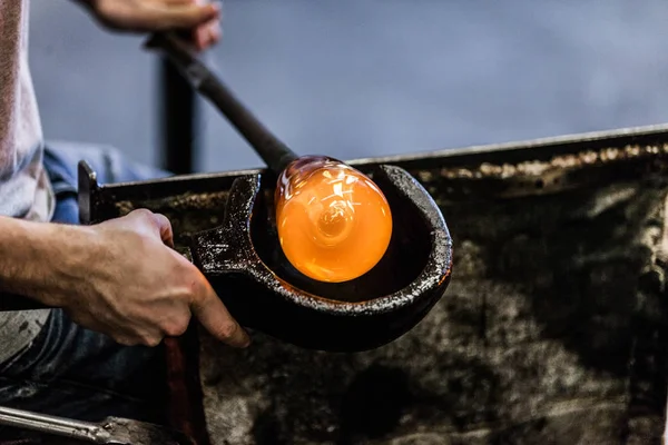 Hombre trabajando en una pieza de vidrio soplado — Foto de Stock