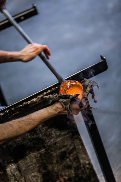 Mann arbeitet an einem mundgeblasenen Glasstück — Stockfoto