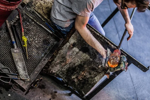 Muž pracuje na kousek foukané sklo — Stock fotografie