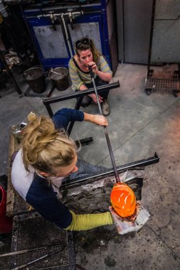 Glass Blowing Workshop - Two Women Shaping glass on the Blowpipe clipart