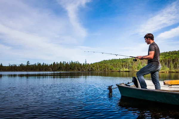 Hombre Pesca trucha en un lago tranquilo — Foto de Stock