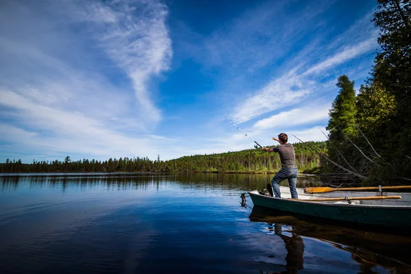 Uomo Trota da pesca in un lago calmo — Foto Stock