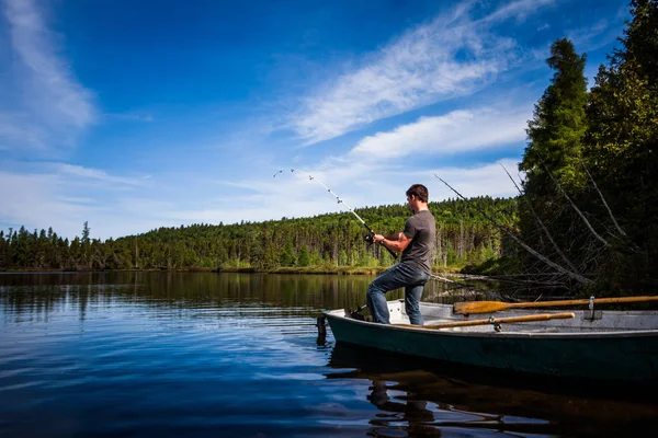 Uomo Trota da pesca in un lago calmo — Foto Stock