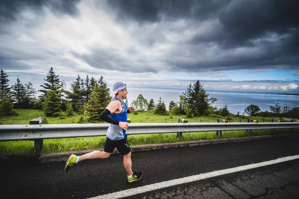 Marathonläufer allein den Berg hinunter — Stockfoto