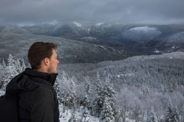 Человек один на вершине горы зимой — стоковое фото