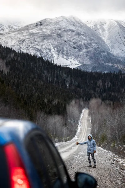 Автостопом по зимней дороге с горами — стоковое фото