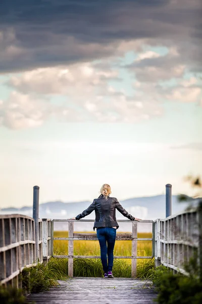 Donna che guarda il paesaggio stupefacente da un balcone — Foto Stock