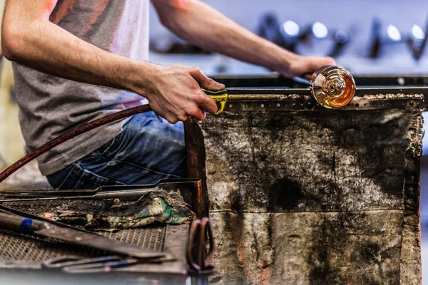 Homem trabalhando em uma peça de vidro soprado — Fotografia de Stock