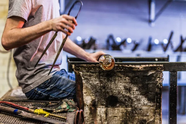 Hombre trabajando en una pieza de vidrio soplado — Foto de Stock