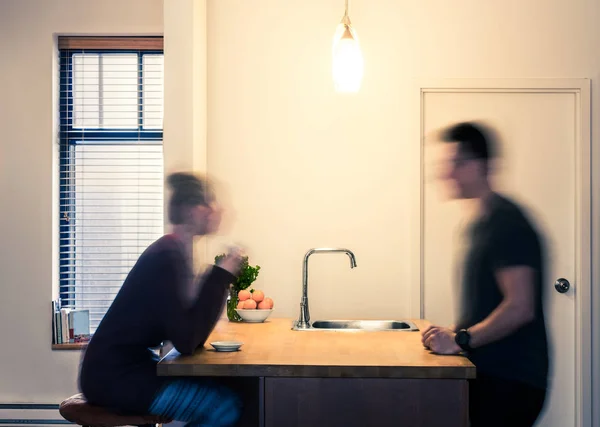 Casal desfocado tomando uma bebida na cozinha — Fotografia de Stock