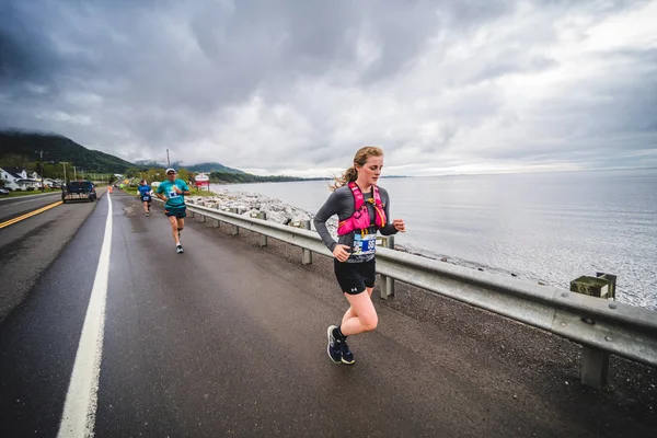 Mulher maratonista levando ao lado da estrada — Fotografia de Stock