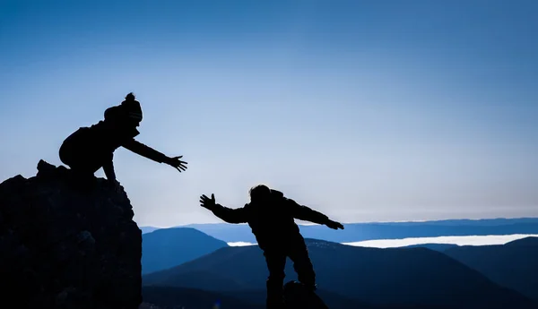 Couple in silhouettes helping each other for Sucess — Stock Photo, Image