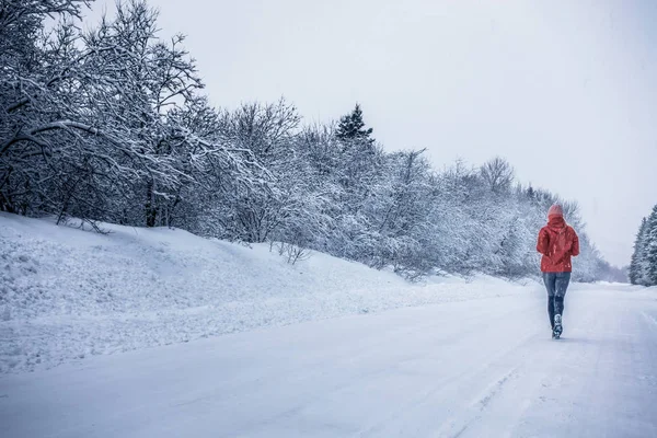 Donna in esecuzione da sola nella foresta invernale — Foto Stock