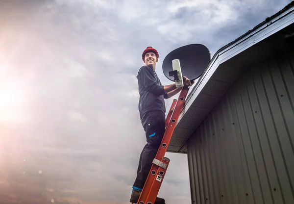 Vrolijke Jongeman Staande Een Ladder Residentiële Satelliet Montage Dak — Stockfoto