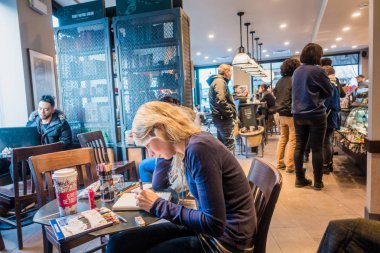 Montreal, Kanada - 1 Aralık 2017: Montreal Starbucks bir kağıt yastık üzerinde çizim genç kadın.