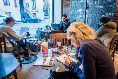 Montreal, Kanada - 1 Aralık 2017: Montreal Starbucks bir kağıt yastık üzerinde çizim genç kadın.