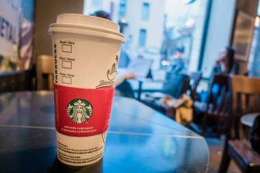 Montreal, Kanada - 1 Aralık 2017: Starbucks kahve fincanı arka plan bulanık insanlarda bir masada.