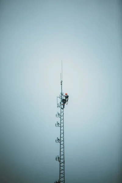 ハーネスとツールのアンテナ塔を登るテレコム ワーカー — ストック写真