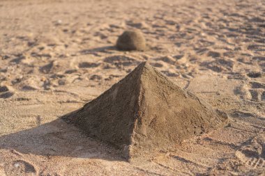 Kumsalda elle yapılan kum piramidi.
