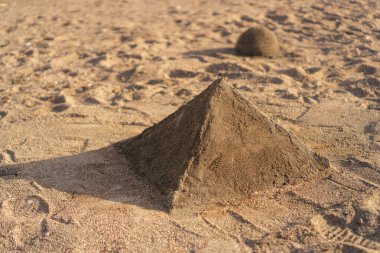 Kumsalda elle yapılan kum piramidi.