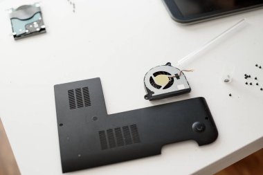 Bilgisayar atölyesinde beyaz masadaki farklı bilgisayar parçaları