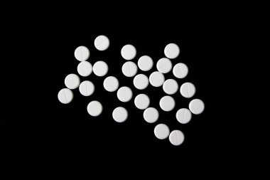 Siyah arka planda beyaz haplar, üst görüş, düz yatış