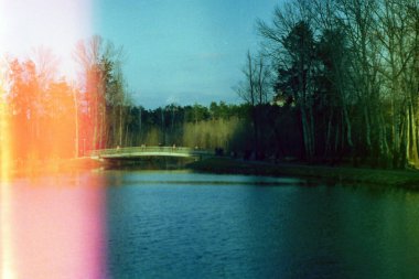 Eski köprü, orman ve göl manzaralı park yeri, 35 mm 'lik bir film.