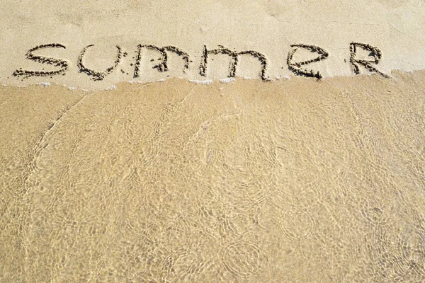 Слово лето написано на песчаной поверхности — стоковое фото