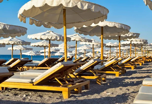 Пляжные кровати и зонтики вблизи — стоковое фото