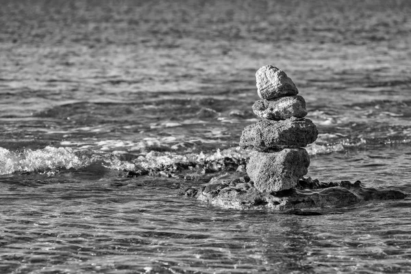 En stenpyramid på havet utrymme — Stockfoto