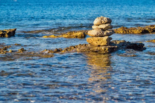 stock image stone pyramid on sea space