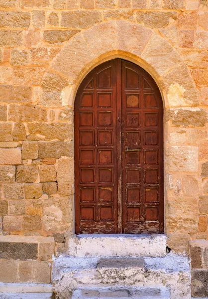 Vecchia porta su un muro antico — Foto Stock