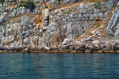 Soyut desenli kayalık kıyılar yakın plan ve arka plan için sakin mavi deniz