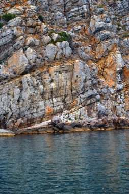 Soyut desenli kayalık kıyılar yakın plan ve arka plan için sakin mavi deniz