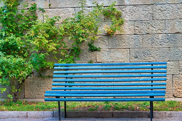 One Empty Blue Garden Bench Closeup Foreground Stone Wall Part — Stock Photo, Image