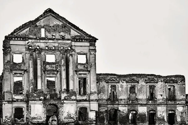 ancient ruins of a ruined old brick building or castle against an empty and clear sky of monochrome tone