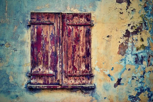旧的木制百叶窗是关闭的 位于一个旧的斑斑墙壁上的特写 以作为抽象的老式背景 — 图库照片
