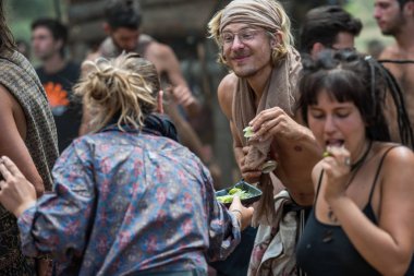 Kadın, psikoz teorisi müzik festivalinin ana sahnesinde dans edenler arasında limon dilimleri dağıtıyor.