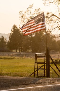 Gün batımı ışığı Terrebonne yakınlarındaki bir Amerikan bayrağından geçer.