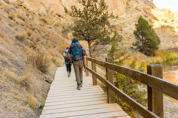 Tırmanışçılar, Smith Rock State Parkı 'nın patikalarından birinin tahta köprüsünün üzerinden geçiyorlar.