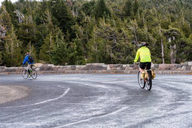 İki bisikletçi Krater Gölü 'nün etrafında bir rota çiziyor.