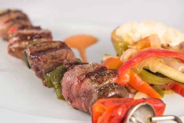 Skewer of iberian pork sirloin with vegetables and baked potato — Stock Photo, Image