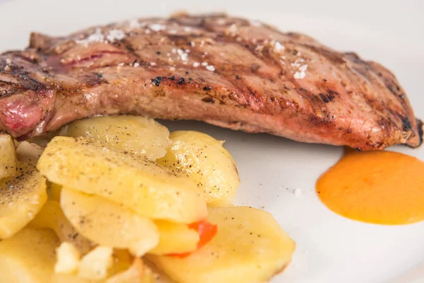 Schotel Iberisch varkensvlees presa met gebakken aardappelschijfjes. — Stockfoto